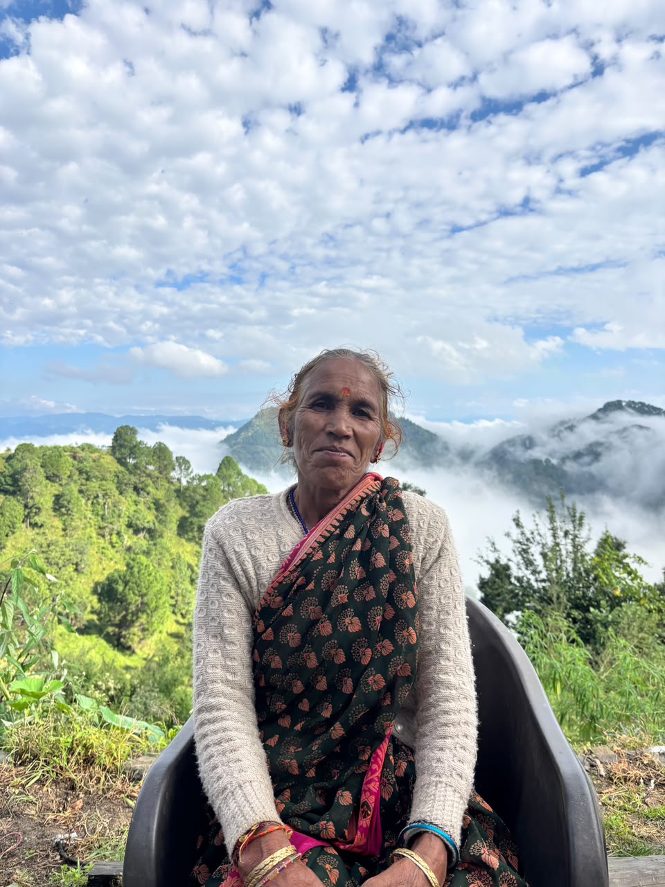 Hari Kadakoti seated outdoors with the mountains behind her